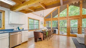 A spacious kitchen with wooden beams, white cabinets, and a large dining table. - NEW LISTING SPECIAL-Mountain Escape Near It All sleeps 8 with 4 bedrooms! (Sevierville)