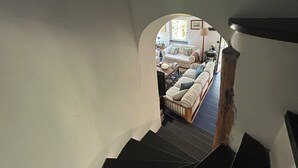 Un escalier menant à un salon équipé d’un canapé, d’une table basse et d’une lampe.