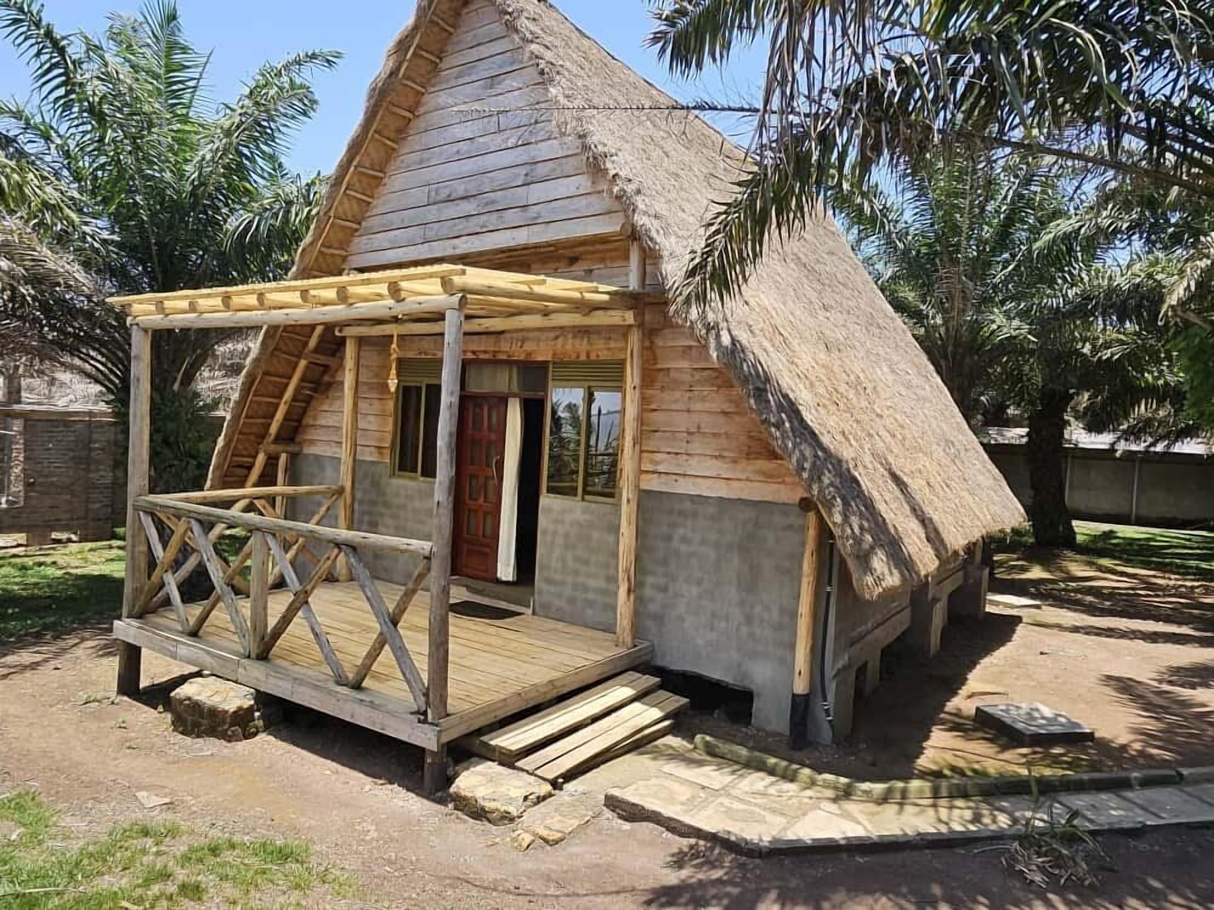 Une construction en bois au toit de chaume, dotée d ’un porche en bois et d’une porte.