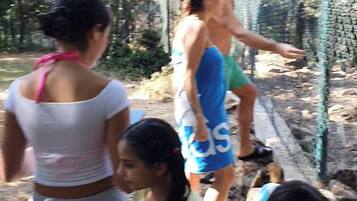 A group of people near a fence in an outdoor setting.