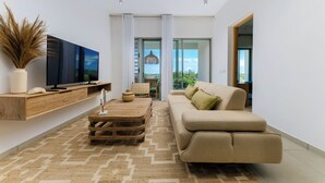 A modern living room with a flat-screen TV, wooden console, and a beige sofa. - TROPICA BLISS (Grand Baie)