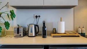 A kitchen counter with a toaster, kettle, electric kettle, and a roll of paper towels. - TROPICA BLISS (Grand Baie)