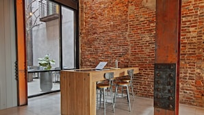 Eine moderne Bar mit einer Holztresore, Metallhockern und einem großen Fenster.