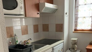 A compact kitchen with a microwave, a built-in oven, a sink, and a refrigerator. - Apartment T2 Vu mountain 700 meters cable car swimming pool in summer (Cauterets)