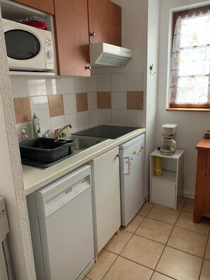 A compact kitchen with a microwave, a built-in oven, a sink, and a refrigerator. - Apartment T2 Vu mountain 700 meters cable car swimming pool in summer (Cauterets)