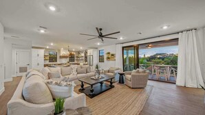 A spacious living room with a large sofa, a coffee table, and a view of a balcony. - 2 Homes–2 Pools/Hot Tubs–Steps from Siesta Beach (Sarasota)