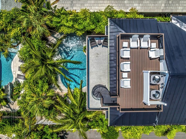Vista aérea de una azotea con piscina, rodeada de abundante vegetación.