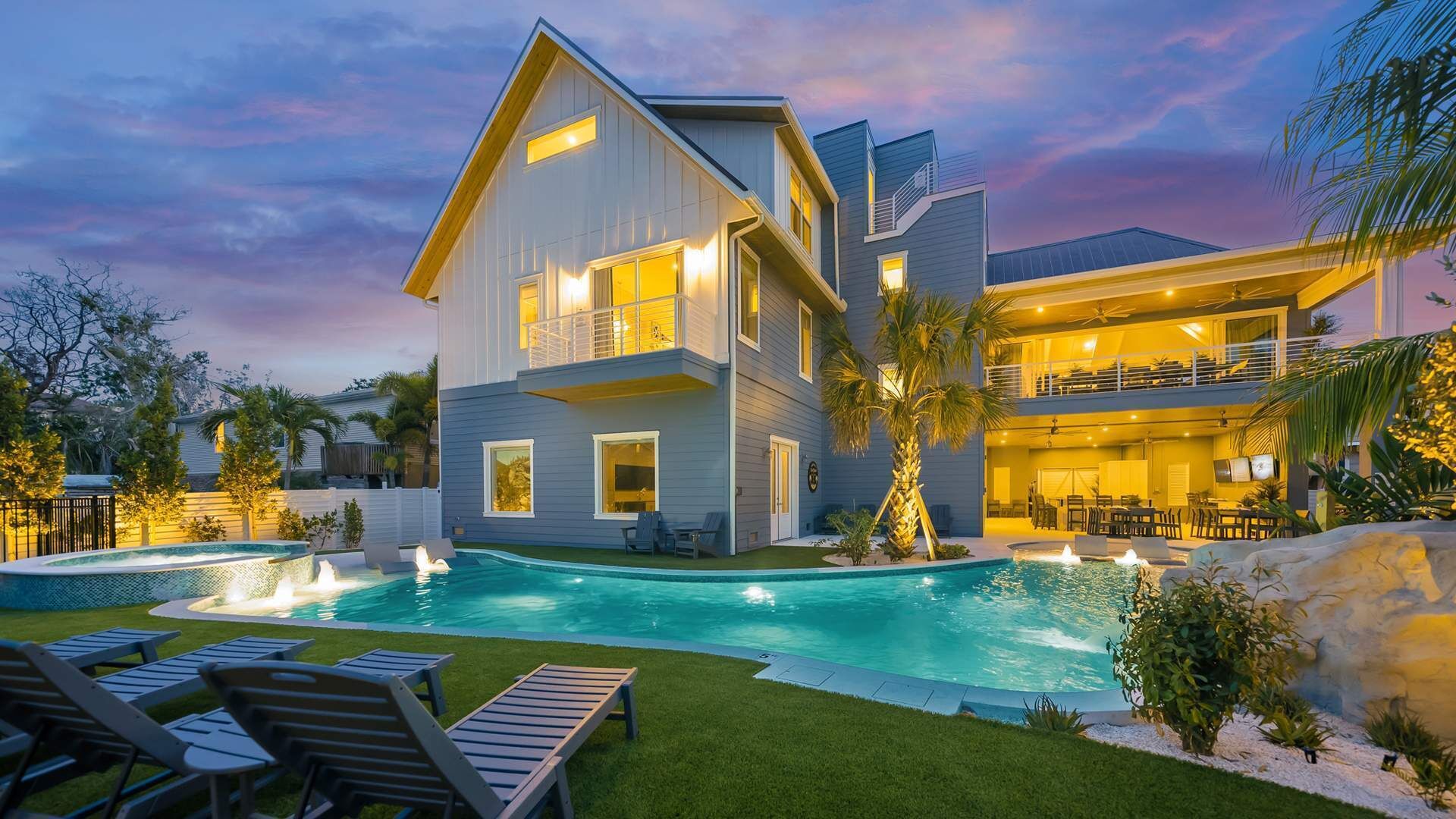 Une maison à deux étages dotée d’une piscine, d’un espace extérieur aménagé pour s’asseoir et d’un patio bien éclairé.