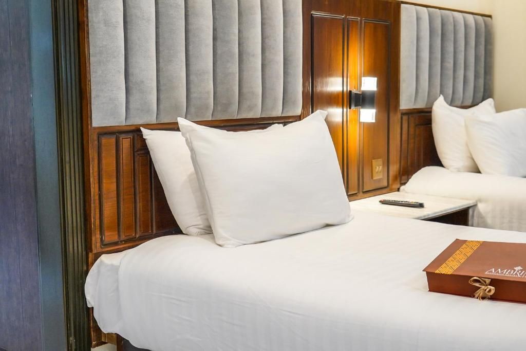A hotel room with a bed, a bedside table, and a wooden headboard.