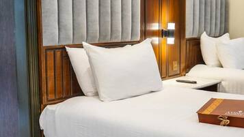 A hotel room with a bed, a bedside table, and a wooden headboard.