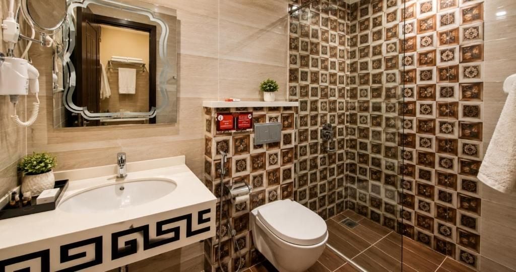 A bathroom with a sink, toilet, and shower area.