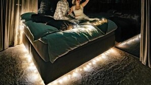 A room with a bed, curtains, and a view of the night sky. - OloResort Levi (Kittilä)