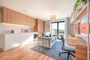 Eine moderne Wohnung mit Küche, Wohnbereich und einem Balkon mit Blick auf die Stadt.