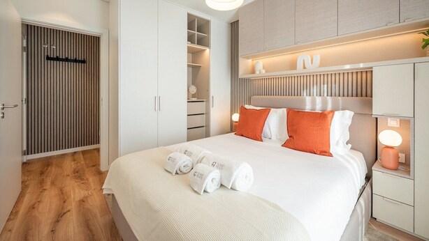 Et moderne hotelværelse med en stor seng, et garderobeskab og et toiletbord.