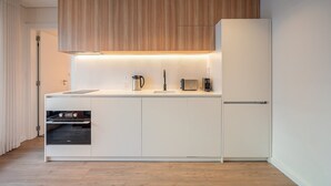 Eine moderne Küche mit weißen Schränken, einem eingebauten Backofen, einer Mikrowelle und einem Toaster.