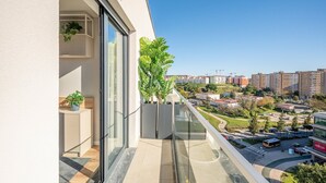 En balkon med udsigt over bybilledet, inklusive bygninger og en vej.