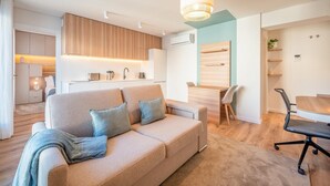 Ein modernes Wohnzimmer mit Sofa, Esstisch und Küchenzeile.