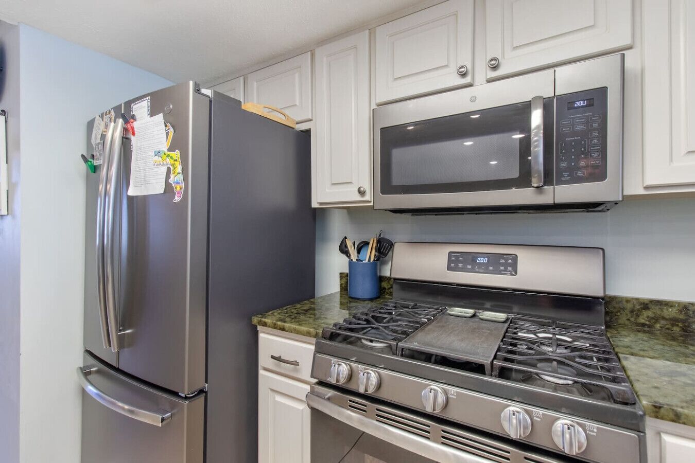 Frigorífico, utensilios de cocina, mesa de comedor y isla de cocina