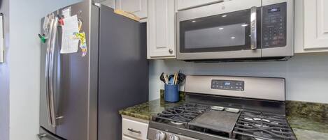 Frigorífico, utensilios de cocina, mesa de comedor y isla de cocina