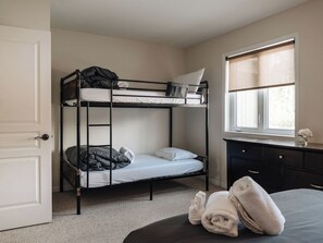 Una cama litera con escritorio y ventana.