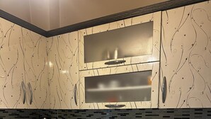 Une cuisine moderne avec des meubles en bois foncé, un plan de travail en granit, un évier en acier inoxydable, un four à micro-ondes et un lave-vaisselle.