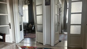 Un hall spacieux doté d’un plancher en bois, d’un tapis patchwork aux couleurs vives et d’un tapis à motifs menant à une pièce.