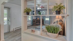 A hallway with a built-in shelf displaying potted plants and a small candle. - Beach Goer’s Paradise (Luna Pier)