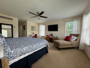 A bedroom with a large bed, a sofa, a TV, and a ceiling fan. - The Battlefield Getaway (Monroe)