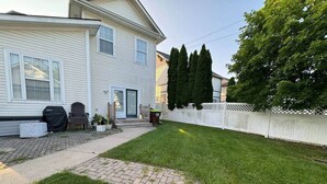 A residential property with a paved driveway, a lawn, and a white fence. - The Battlefield Getaway (Monroe)