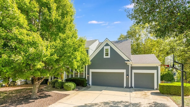 A two-story house with a gray exterior, two garage doors, and a basketball hoop in the driveway. - The Yellow House - hot tub, pool table, fire pit, 6 bedrooms (Liberty)