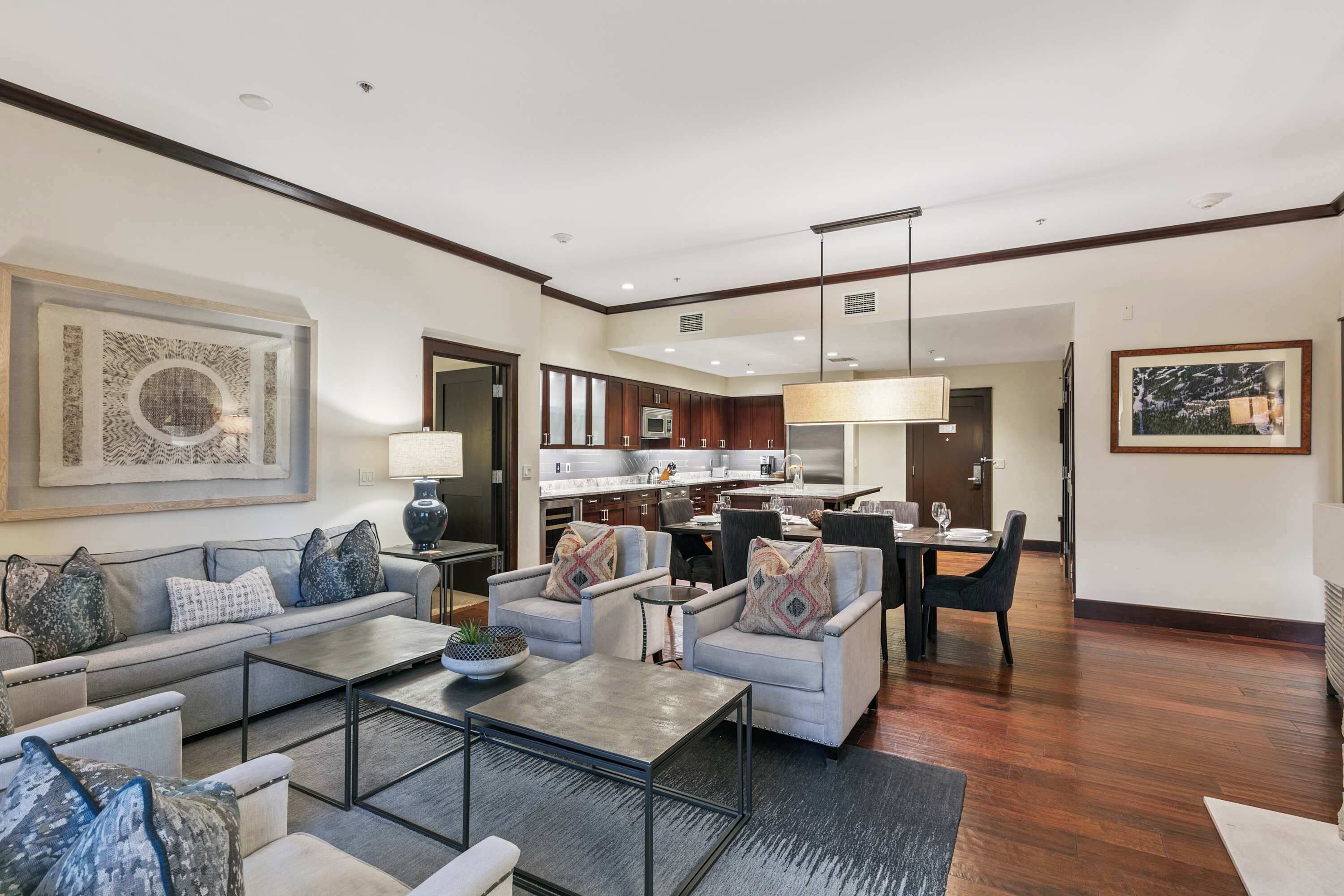 A modern living room with a sofa set, a coffee table, and a dining area with chairs.
