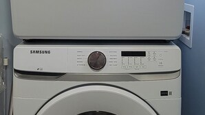 Zwei übereinander gestellte Samsung Waschmaschinen mit Frontlader in einem Waschraum.