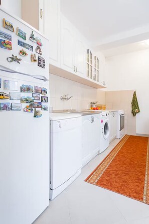 Una cocina moderna con armarios blancos, una lavadora y una secadora.