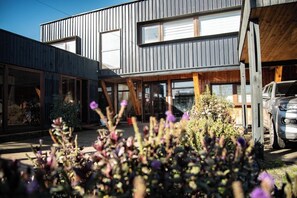 En moderne bygning med to etager, store vinduer og en træterrasse.