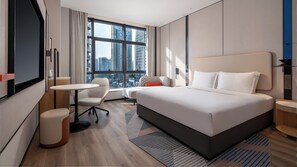 A modern hotel room with a large bed, a desk, a chair, and a view of the cityscape through the window. - Holiday Inn Express Chengdu Phoenix Mountain By Ihg (Chengdu)