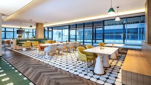 A modern restaurant with a mix of seating options, large windows, and a patterned floor. - Holiday Inn Express Chengdu Phoenix Mountain By Ihg (Chengdu)
