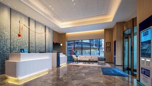 A modern hotel lobby with a reception desk, seating area, and large windows offering views of the city. - Holiday Inn Express Chengdu Phoenix Mountain By Ihg (Chengdu)
