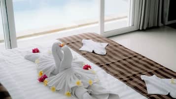 Een hotelkamer met een bed, een gestreept badmatje en uitzicht op een zwembad.