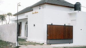 A modern white building with a wooden gate and a sign that reads "Casa Vanna". - Casa Verona Villa Lovina Bali (Buleleng)