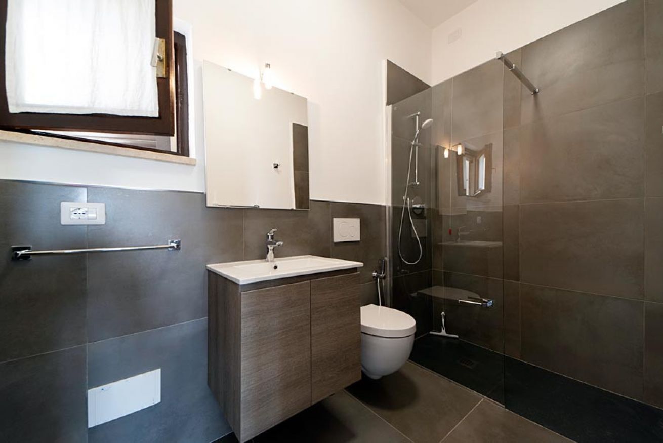 Ein modernes Badezimmer mit Waschbecken, Toilette und einer Duschkabine.