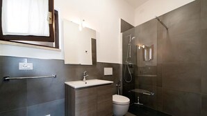 Ein modernes Badezimmer mit Waschbecken, Toilette und einer Duschkabine.
