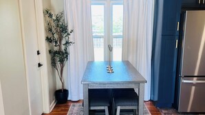 A kitchen with a wooden table, a potted plant, and a refrigerator. - Cozy 2-bedroom house in Enid (Enid)