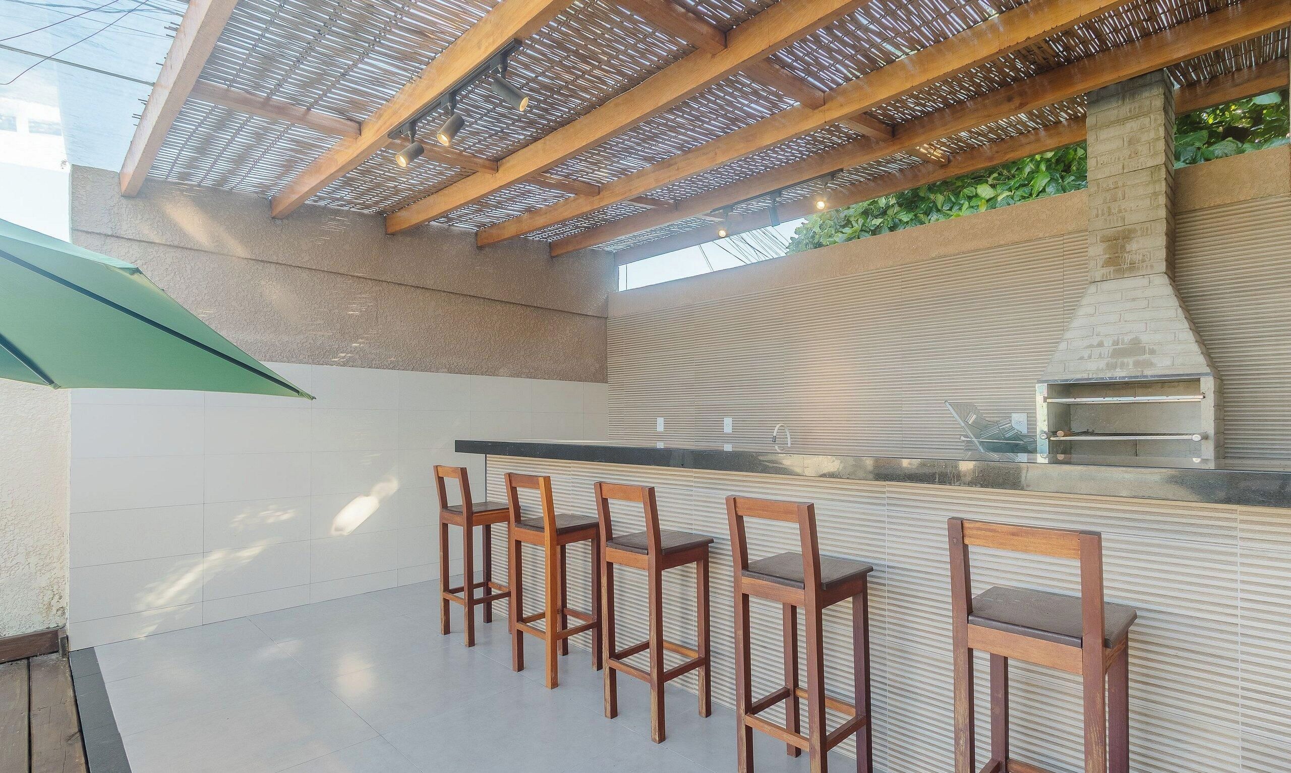 An outdoor kitchen area with a bar and seating.