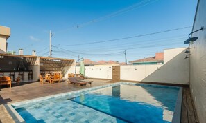A rooftop pool with wooden deck seating and a barbecue area. - House in Condo w/ Pool and Barbecue Grill Bme0001 (Porto Seguro)