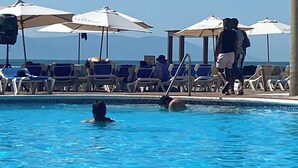 Ein Poolbereich mit Liegestühlen und Sonnenschirmen.