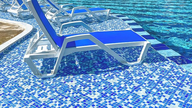 A hotel with a swimming pool, lounge chairs, and palm trees. - FAFA Aqua Blue Hotel (Golem)