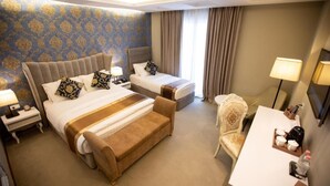 A hotel room with two beds, a desk, a chair, and a nightstand. - FAFA Aqua Blue Hotel (Golem)