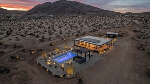 A modern house with a swimming pool, surrounded by desert landscape and mountains. - Luxury 20-Acre Fully-Fenced Oasis • Pool, Spa & Stunning Views • 10 mins to JTNP (Joshua Tree)