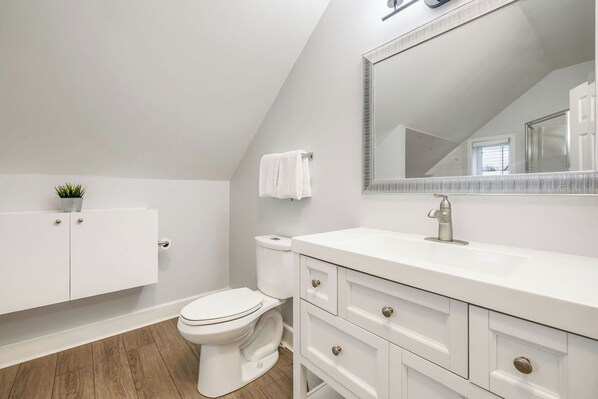 A modern bathroom with a white vanity, a toilet, and a large mirror. - Liisa's Lodge (The Blue Mountains)