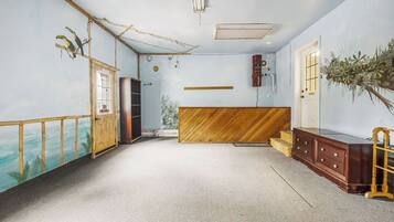 A room with a wooden bench, a wooden cabinet, and a door.